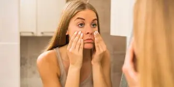 девушка с Ozempic face рассматривает себя в зеркало