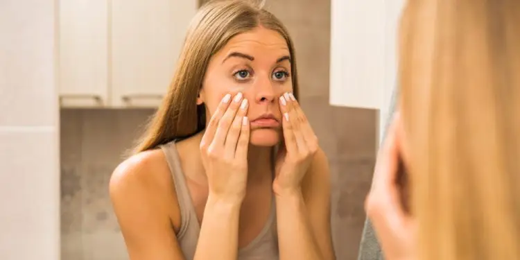 девушка с Ozempic face рассматривает себя в зеркало