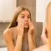 девушка с Ozempic face рассматривает себя в зеркало